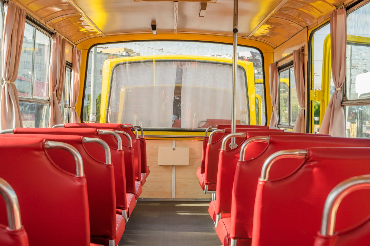 Explore the cozy interior of a yellow bus with vibrant red seats, parked in Wrocław, Poland.